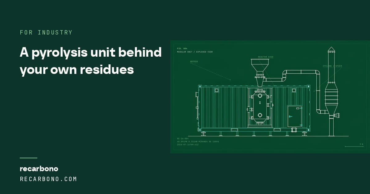 A compact pyrolysis unit sited beside an agro-industrial building.